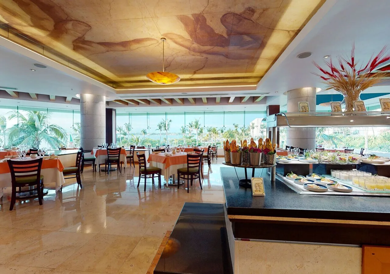 Restaurant dining room with buffet station and ocean-facing windows at Grand Park Royal Cancun.