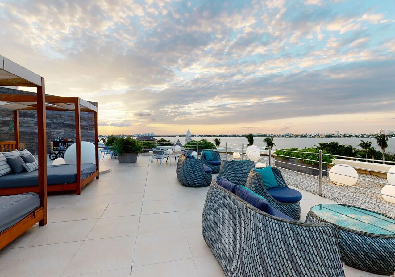 Rooftop terrace lounge with woven seating and lagoon views at Grand Park Royal Cancun.