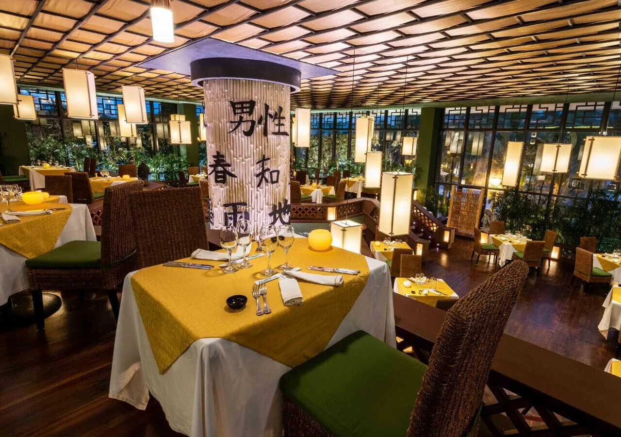 Elevated dining room with yellow table settings at Grand Park Royal Cancun.