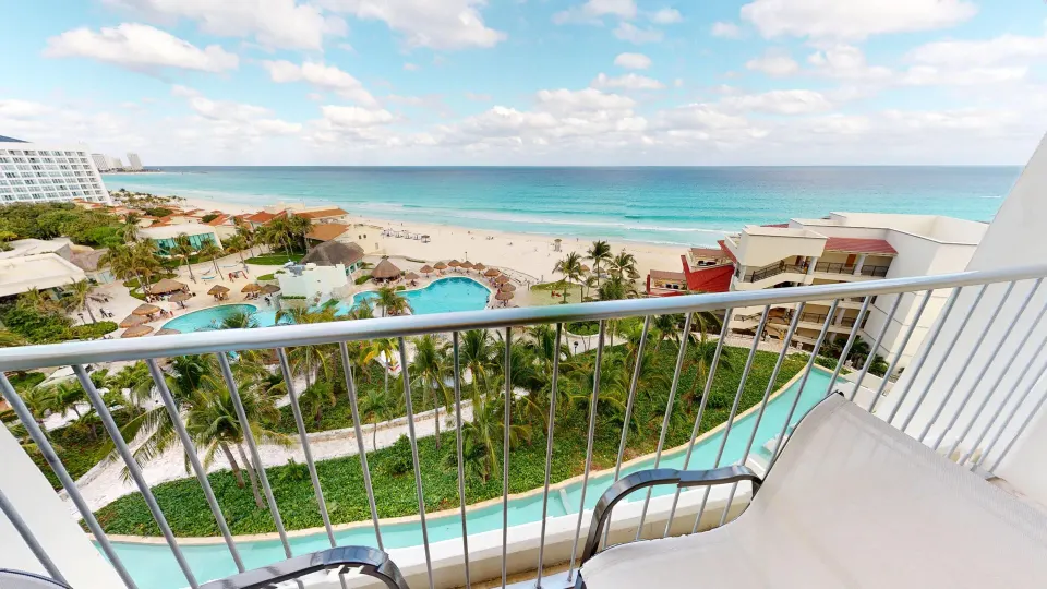 Deluxe Ocean View balcony overlooking beach and pools at Grand Park Royal Cancun.