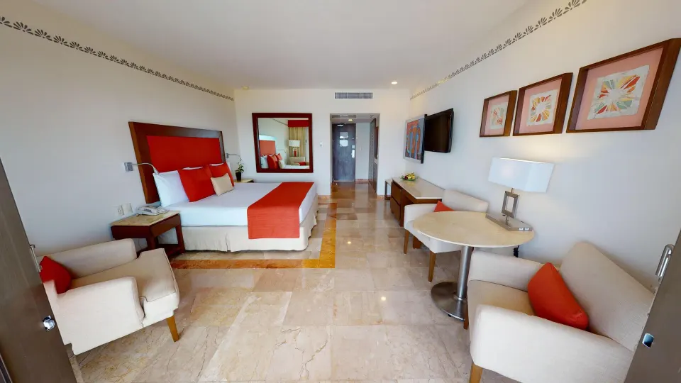 Deluxe Ocean View king bed and seating area at Grand Park Royal Cancun.