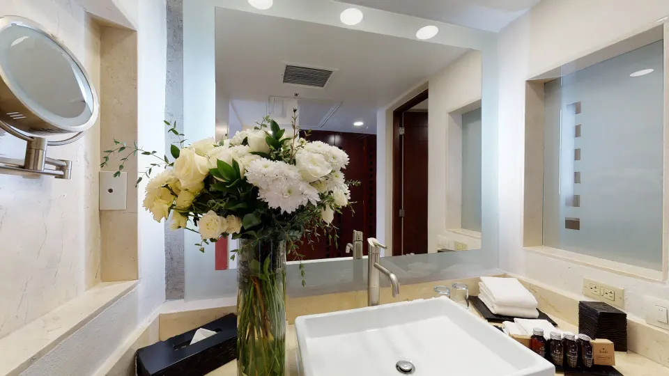 Deluxe Swim Up bathroom sink with flowers and mirror at Grand Park Royal Cancun.