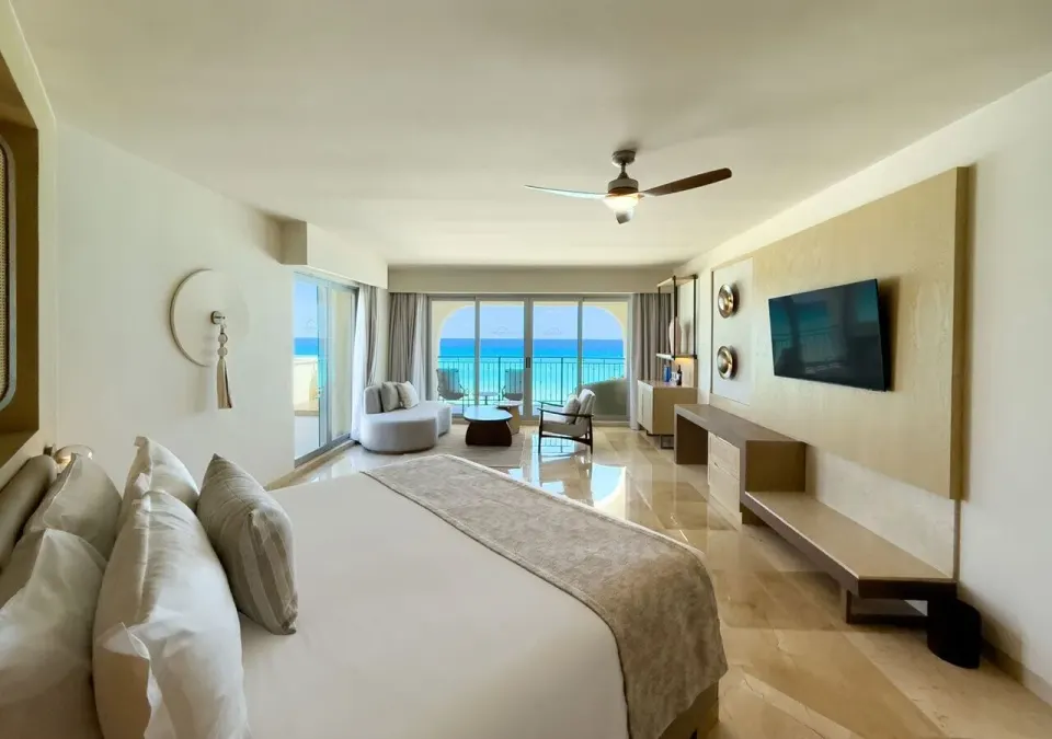 Grand Royal Suite king bed and ocean-view lounge at Grand Park Royal Cancun.