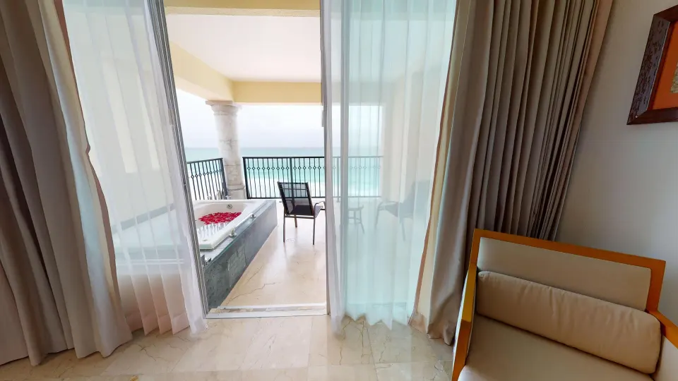Master Suite balcony access with curtains, seating and outdoor tub at Grand Park Royal Cancun.