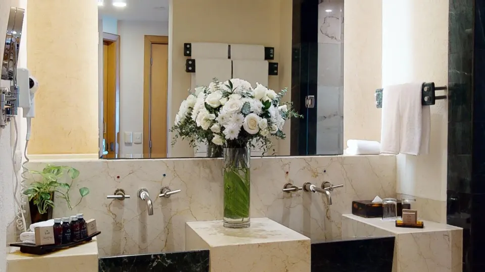 Master Suite bathroom vanity with flowers and twin sinks at Grand Park Royal Cancun.