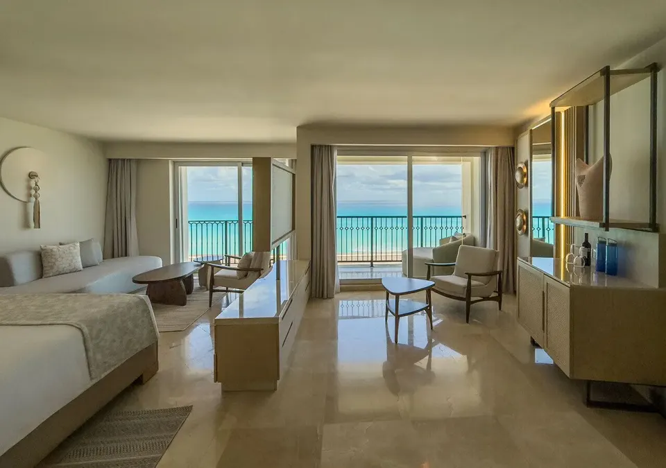 Royal Master Suite king bed and lounge area with ocean windows at Grand Park Royal Cancun.