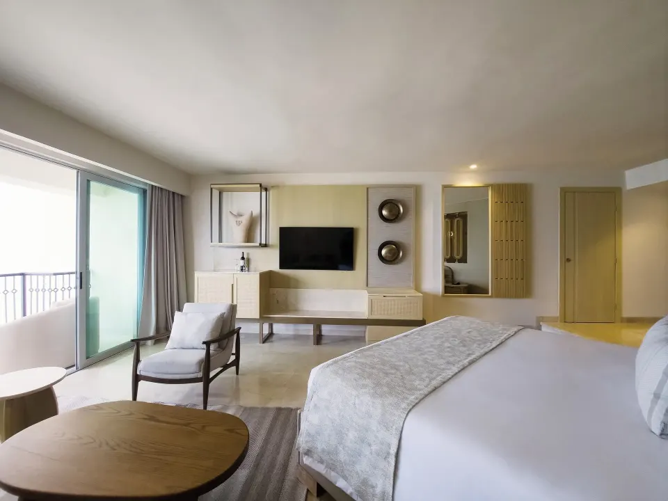 Royal Suite king bed with TV wall and balcony at Grand Park Royal Cancun.
