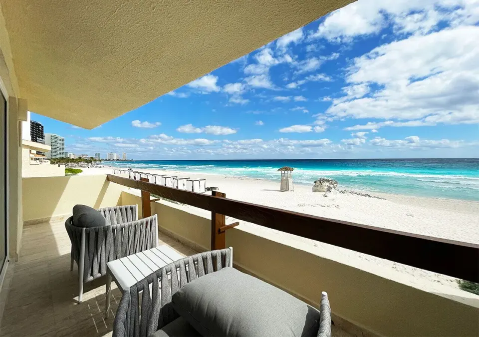 Villa Deluxe Ocean Front balcony with chairs and beach at Grand Park Royal Cancun.