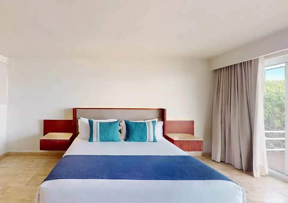 Villa Premier Plungepool Oceanfront king bed with balcony doors at Grand Park Royal Cancun.