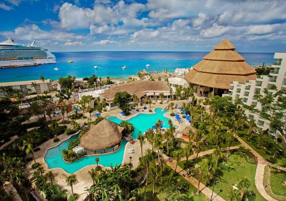 Aerial view of resort pools, thatched palapa and ocean at Grand Park Royal Cozumel