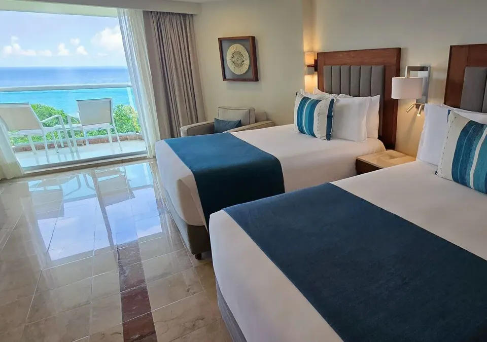 Two double beds and balcony overlooking the ocean at Grand Park Royal Cozumel