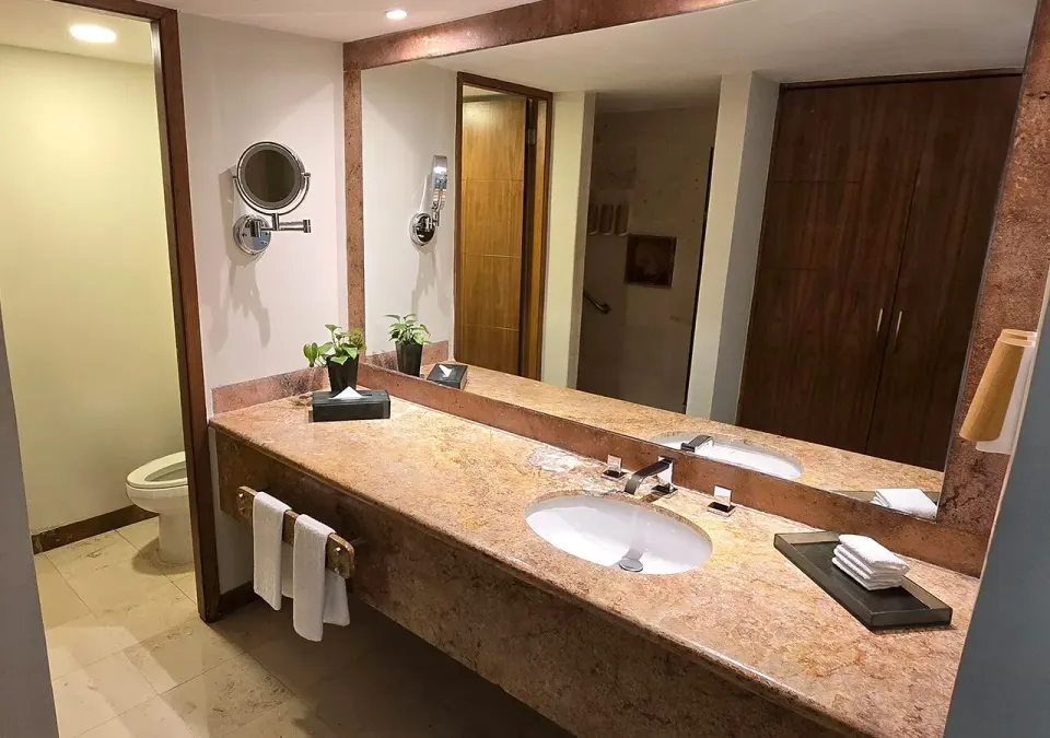 Double sink marble vanity with mirror and toilet visible in a Grand Park Royal Cozumel bathroom.