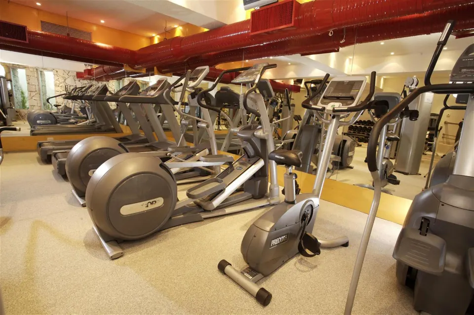 Resort fitness center with cardio machines and mirrors at Grand Park Royal Cozumel