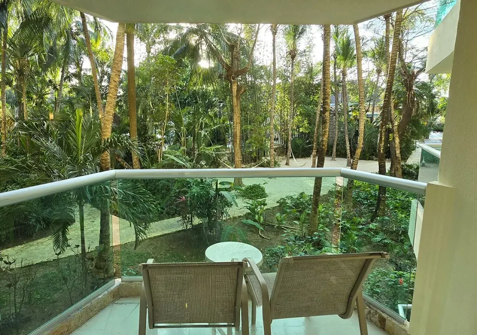 Private balcony with two chairs overlooking a lush garden at Grand Park Royal Cozumel