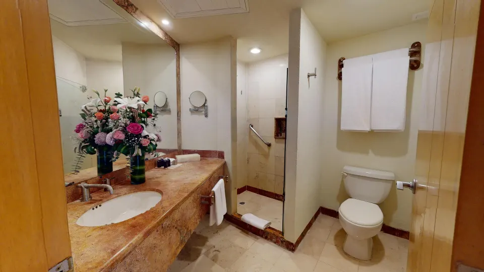 Marble sink and toilet in a guest bathroom at Grand Park Royal Cozumel.