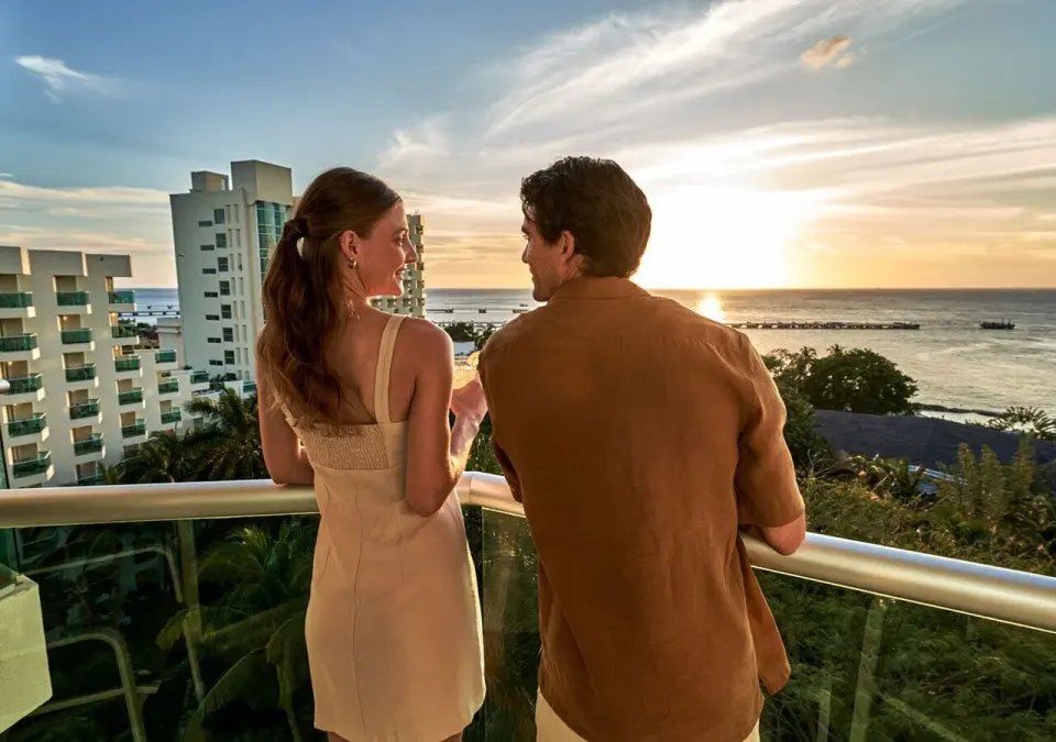 Couple on a balcony watching the sunset over the ocean at Grand Park Royal Cozumel