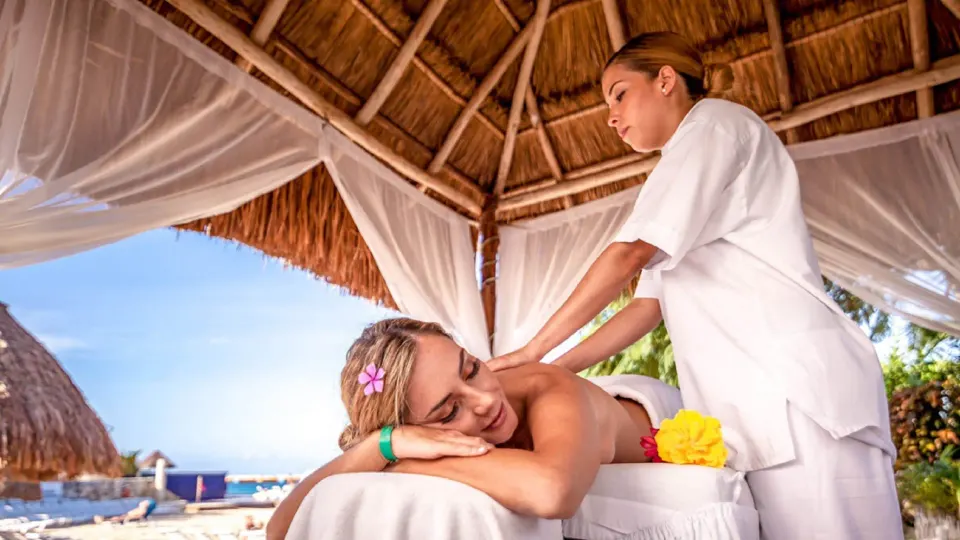 Guest receiving an outdoor massage in a thatched palapa at Grand Park Royal Cozumel