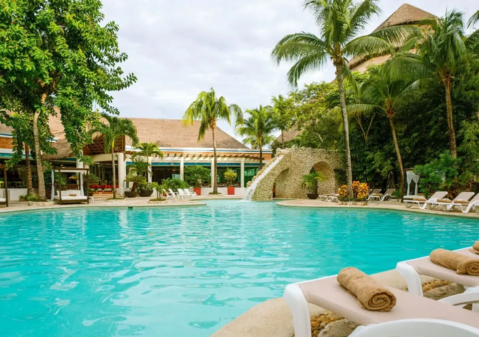 Resort swimming pool with loungers and tropical landscaping at Grand Park Royal Cozumel