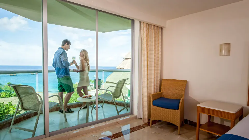 Couple on balcony overlooking ocean from suite at Grand Park Royal Cozumel