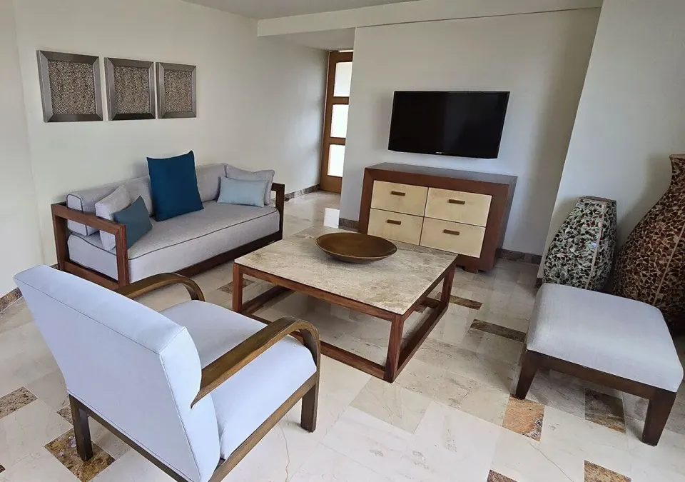 Living area with TV, sofa and chairs at Grand Park Royal Cozumel