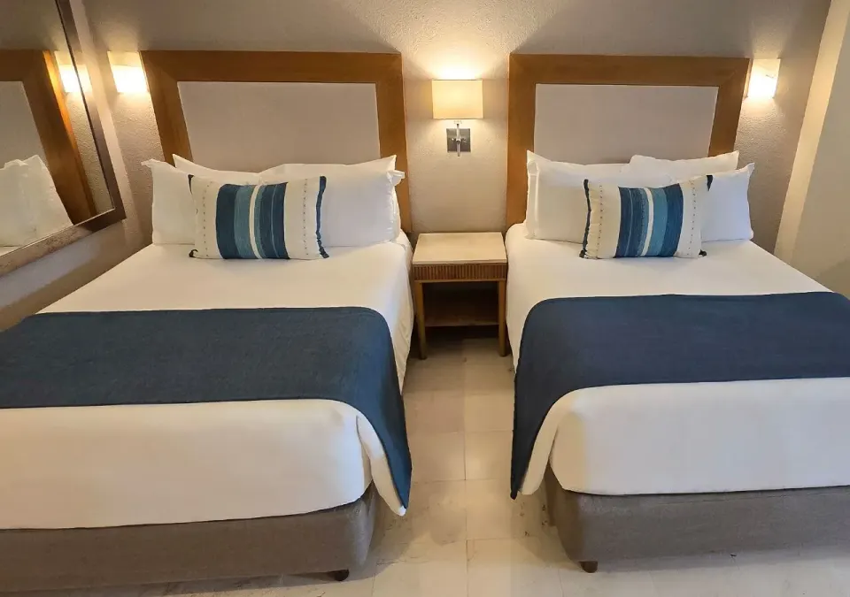 Two double beds side-by-side with night table at Grand Park Royal Cozumel