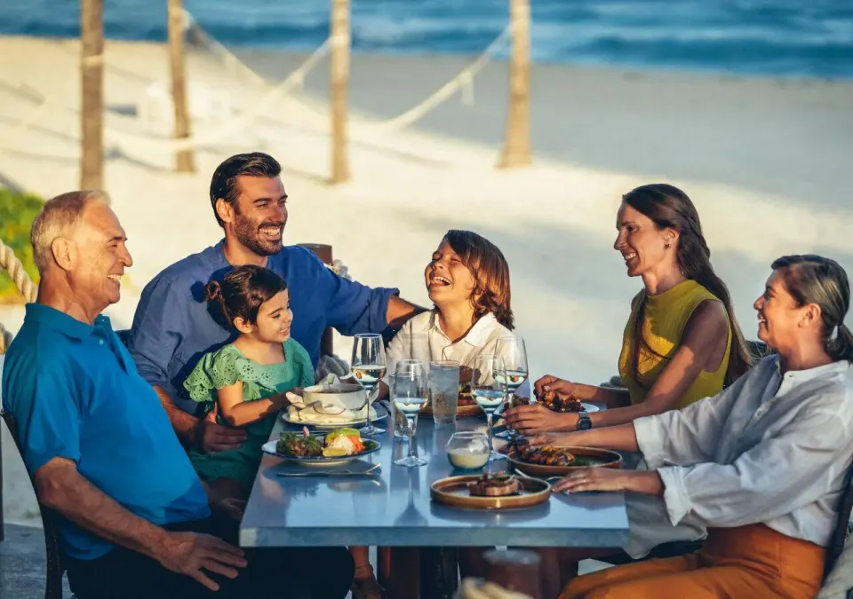 Family dining together on the beach at Grand Park Royal Cozumel