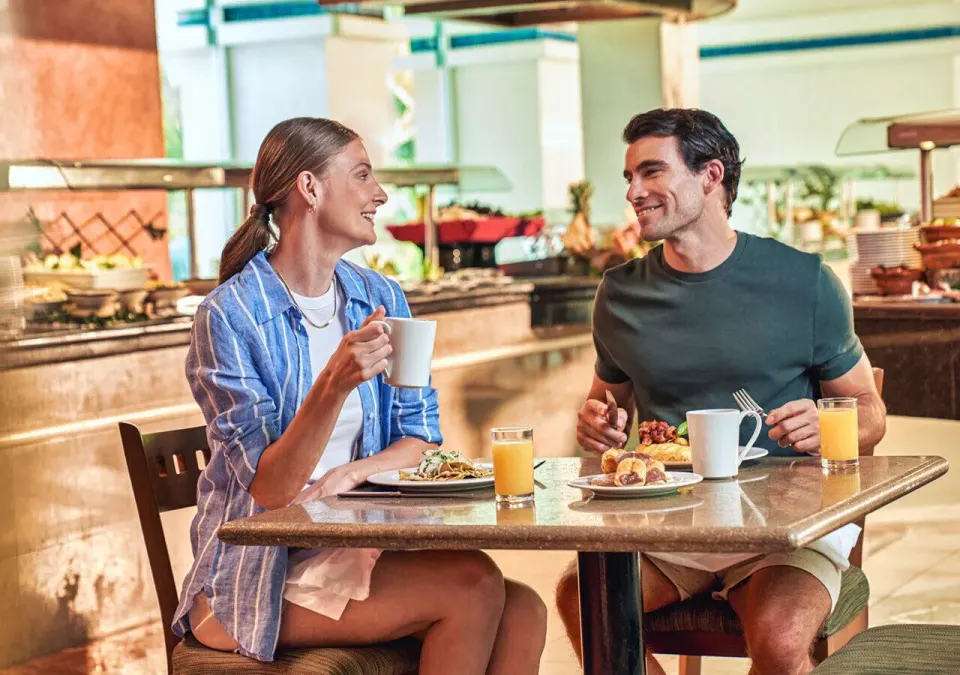 Couple enjoying breakfast together near a buffet at Grand Park Royal Cozumel