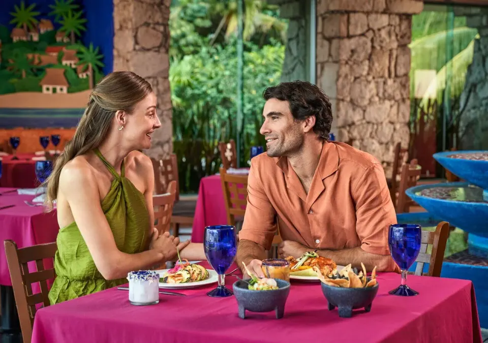 Couple enjoying a colorful indoor dinner at Grand Park Royal Cozumel