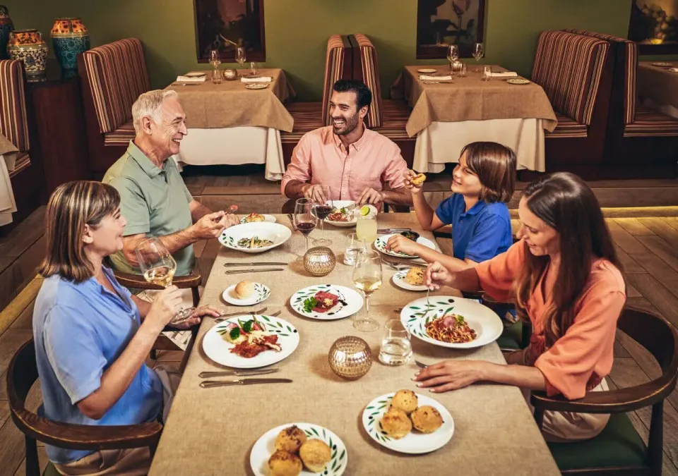 Family enjoying a plated dinner together at Grand Park Royal Cozumel