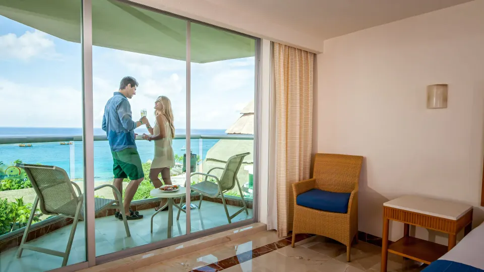 Guests enjoying the ocean view from a balcony of a deluxe room at Grand Park Royal Cozumel