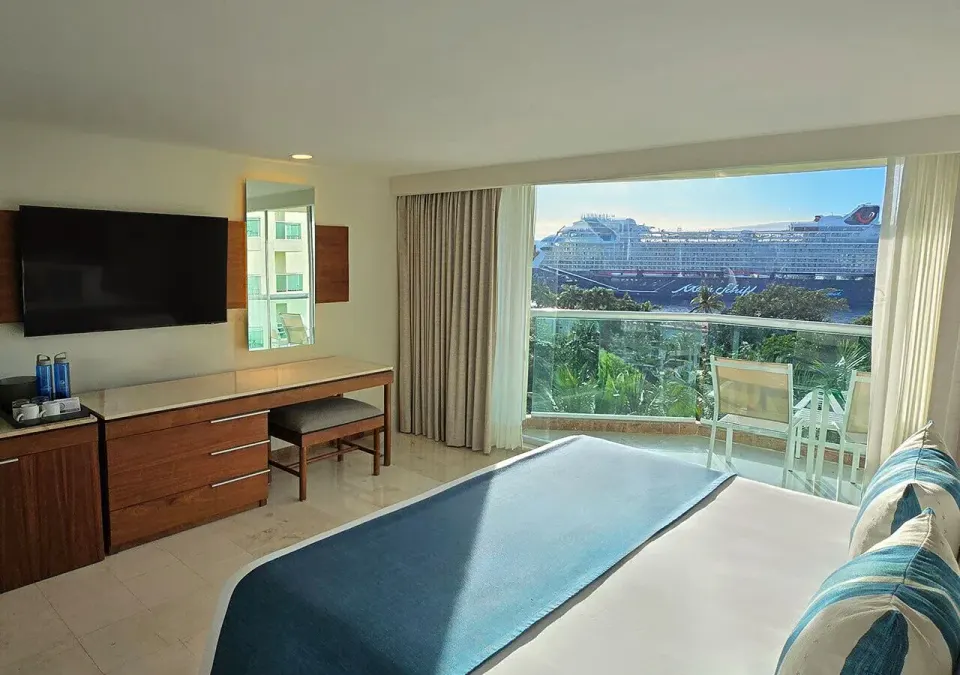 Deluxe High Floor King room with bed, desk and balcony view at Grand Park Royal Cozumel
