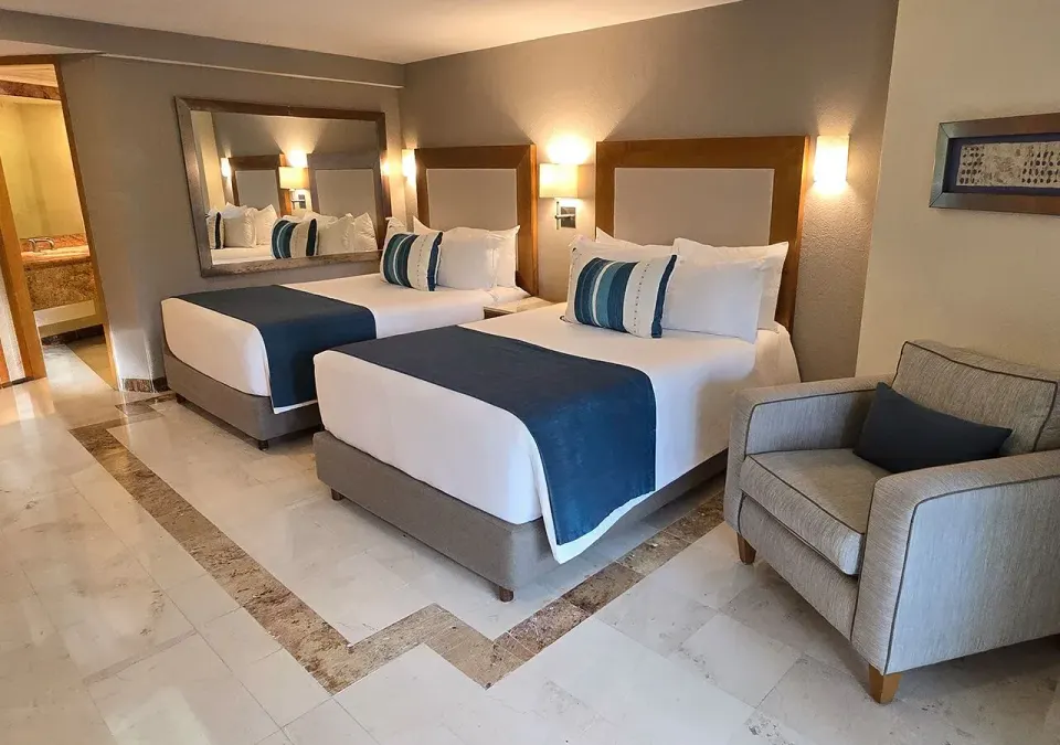 Two double beds and armchair in Deluxe Nature View Double at Grand Park Royal Cozumel