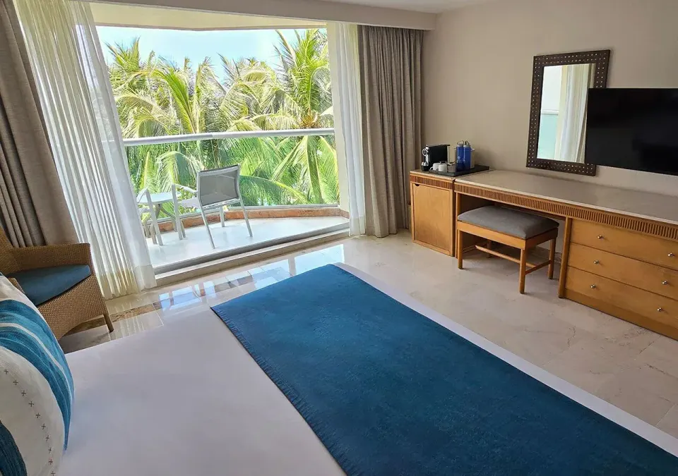 Room view toward balcony with desk, TV and king bed in Deluxe Nature View King at Grand Park Royal Cozumel