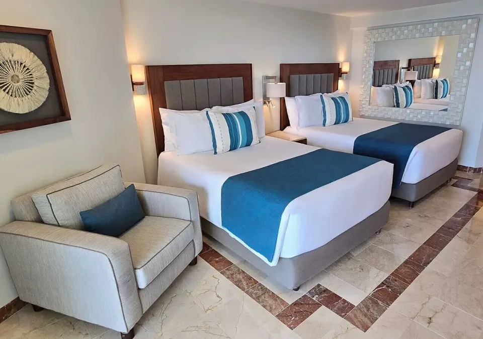 Two double beds and seating area in a Deluxe Superior Ocean View Room at Grand Park Royal Cozumel