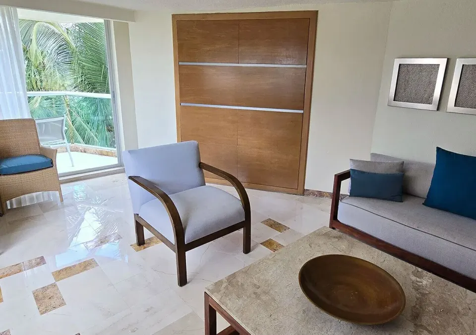 Family Suite seating area with armchair and balcony at Grand Park Royal Cozumel