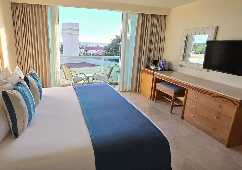 Junior Suite with king bed and balcony overlooking the water at Grand Park Royal Cozumel