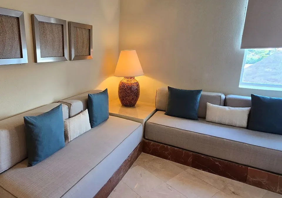 Junior Suite seating area with built-in sofas and lamp at Grand Park Royal Cozumel