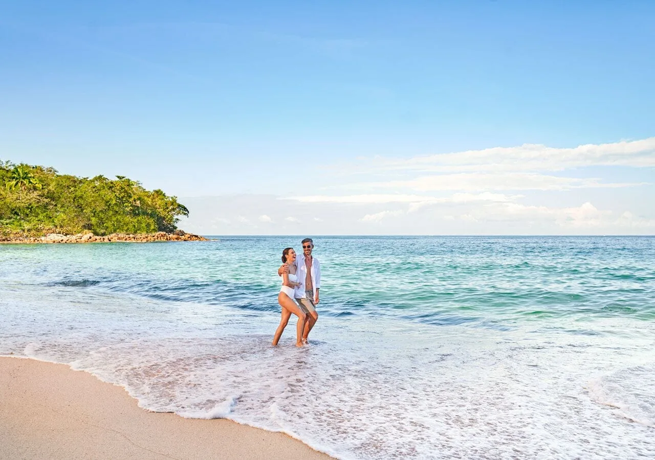 Couple walking in the surf on the beach at Grand Park Royal Puerto Vallarta.