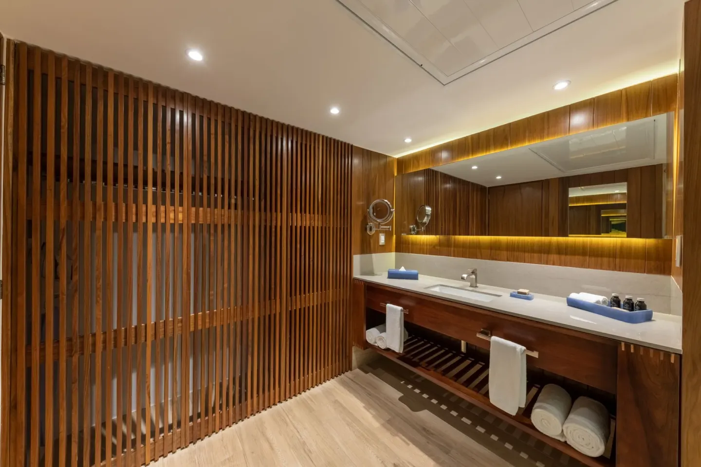 Bathroom vanity with wood slat shower screen at Grand Park Royal Puerto Vallarta.