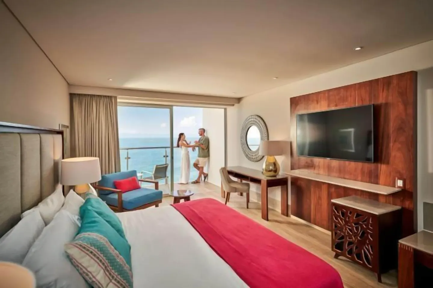 King bed guest room with balcony, ocean view and wall-mounted TV at Grand Park Royal Puerto Vallarta.