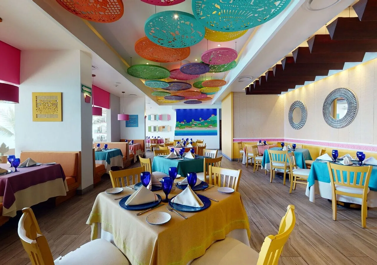 Colorful restaurant with papel picado ceiling decor at Grand Park Royal Puerto Vallarta.