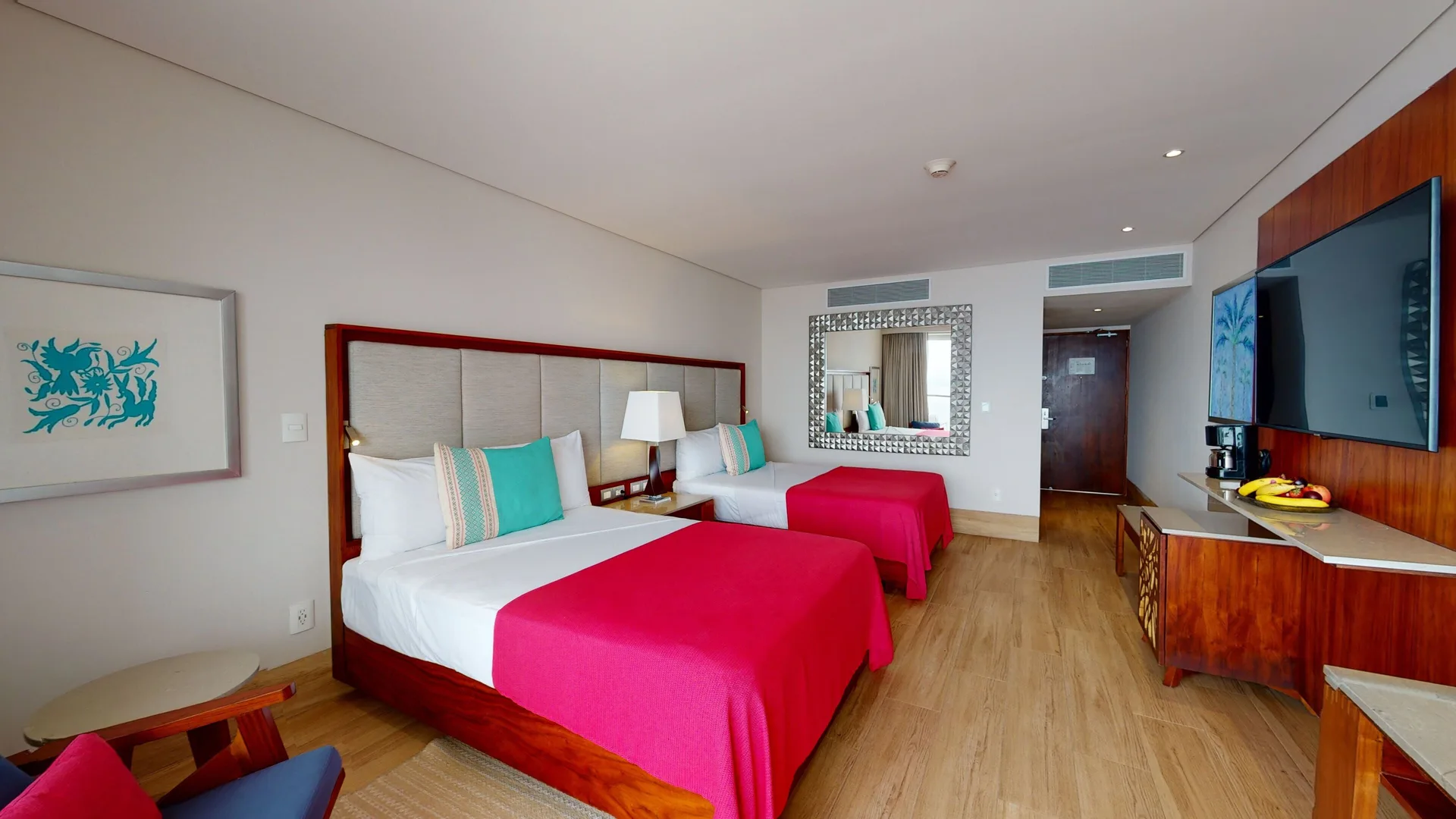 Deluxe Room with two beds and pink bed throws at Grand Park Royal Puerto Vallarta.