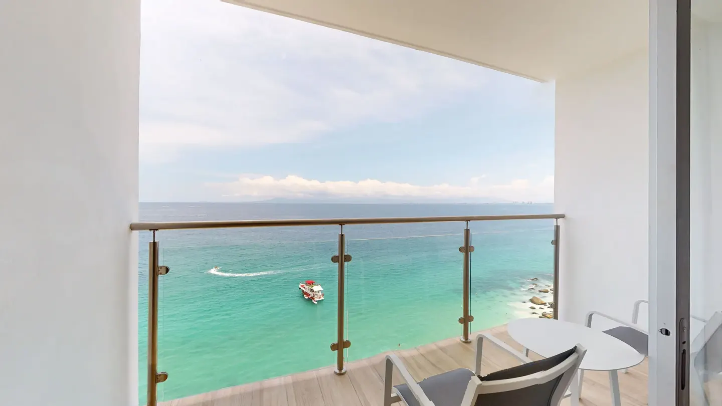 Deluxe room balcony with chairs and ocean view at Grand Park Royal Puerto Vallarta.