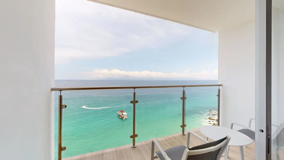 Deluxe room balcony with chairs and ocean view at Grand Park Royal Puerto Vallarta.