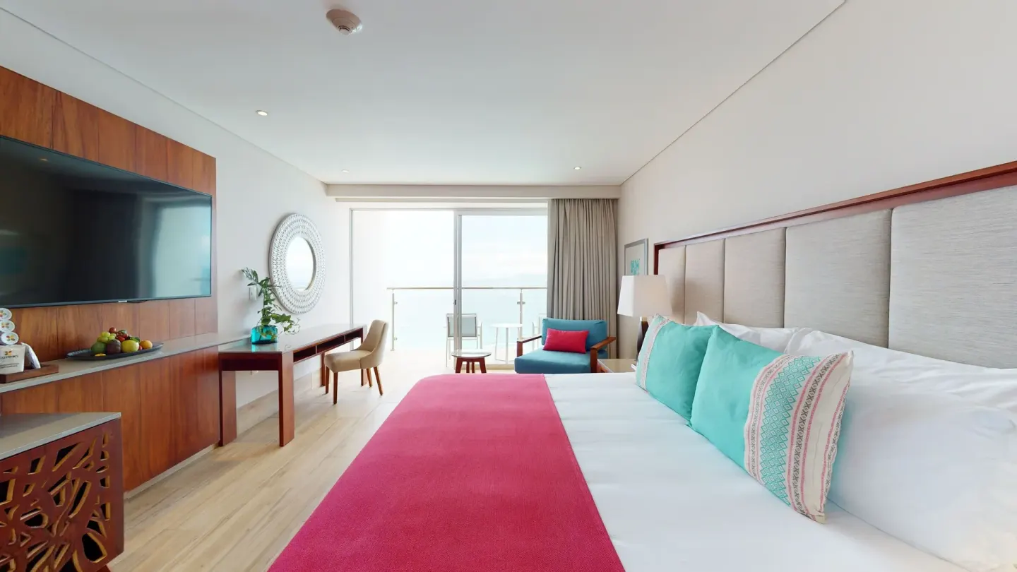 Deluxe room king bed with balcony doors at Grand Park Royal Puerto Vallarta.