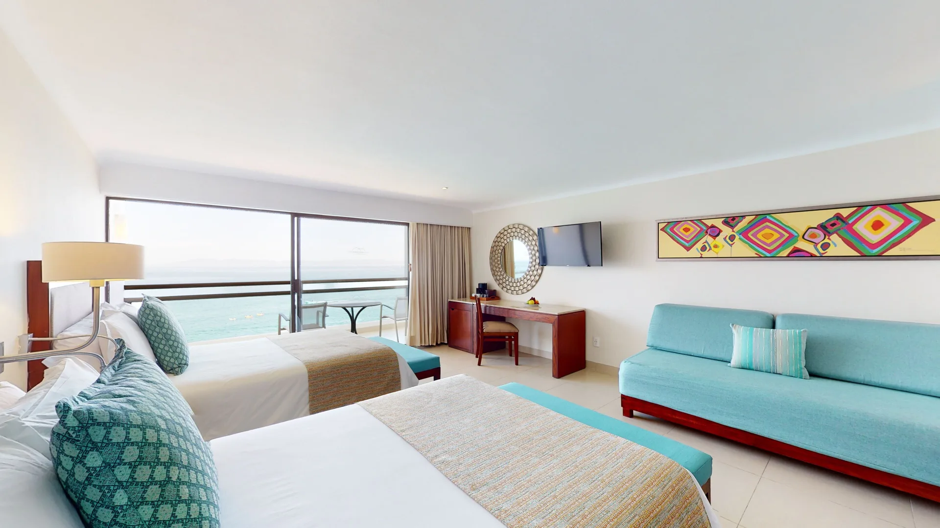 Family Suite Ocean View beds, sofa and balcony at Grand Park Royal Puerto Vallarta.