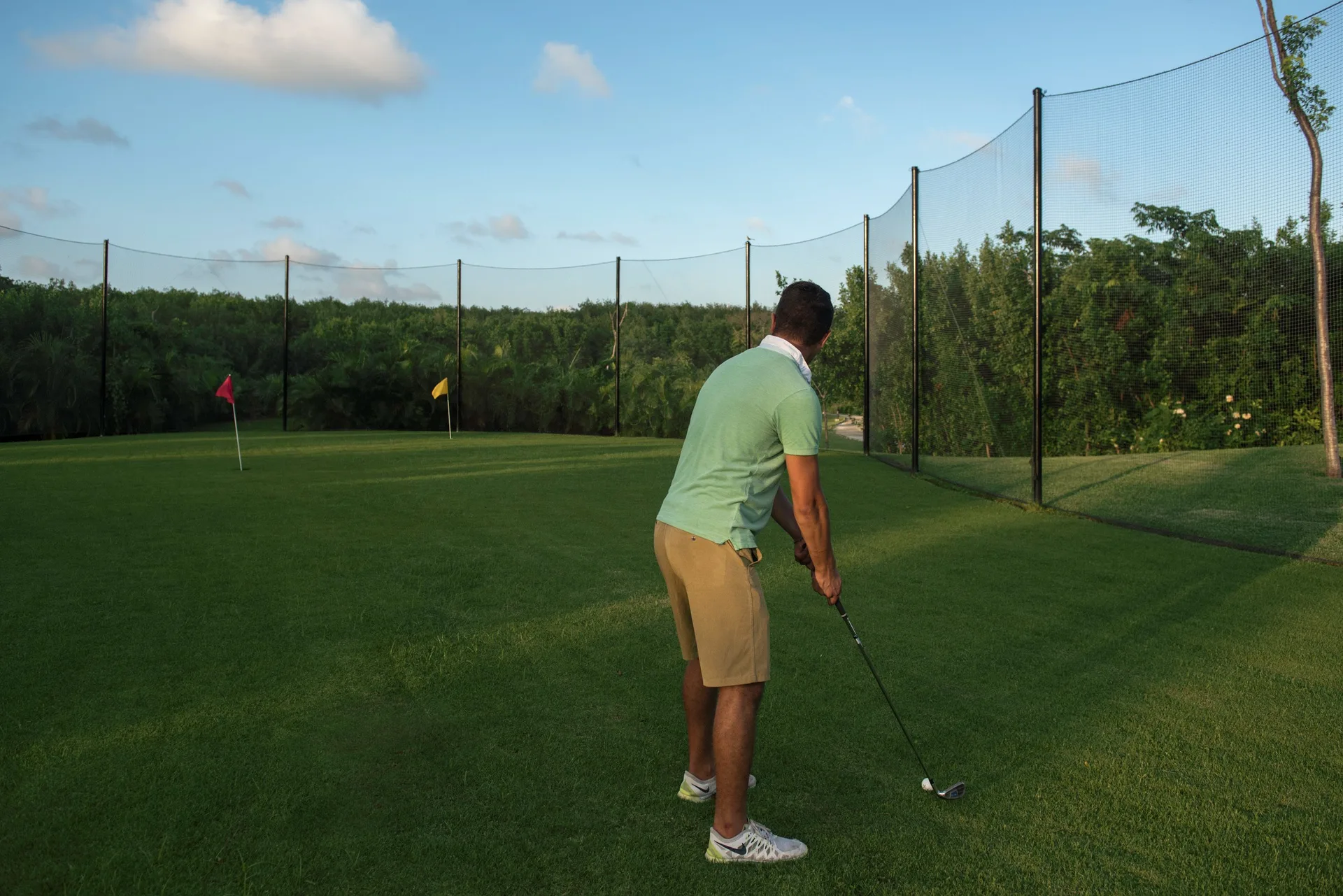 A golfer practices on a netted green at Grand Riviera Princess.