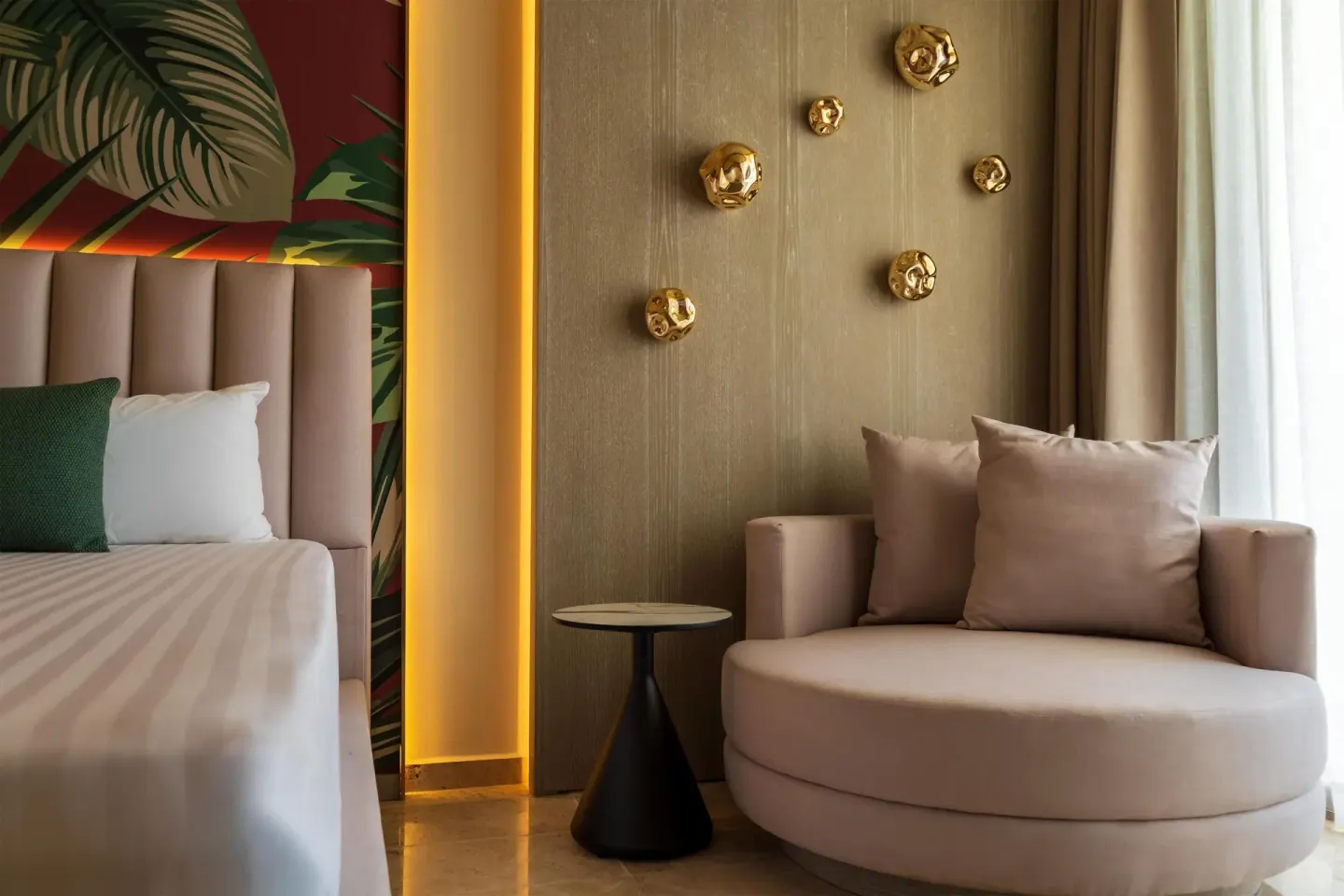 Guest room bed and round lounge chair inside Grand Riviera Princess.