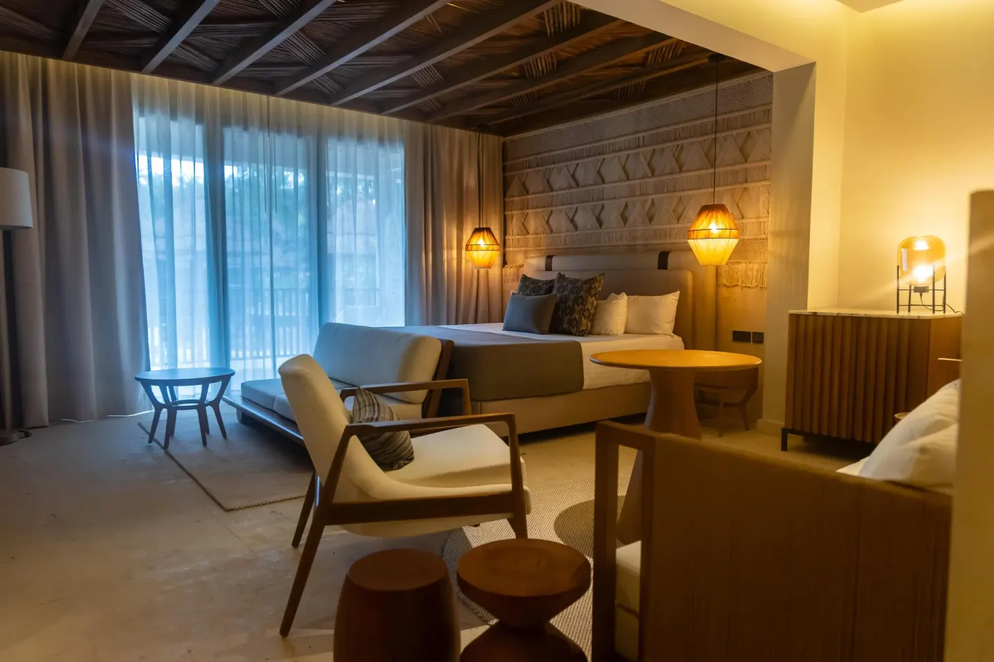 Guest room with king bed, lounge chairs and round table at Grand Riviera Princess.