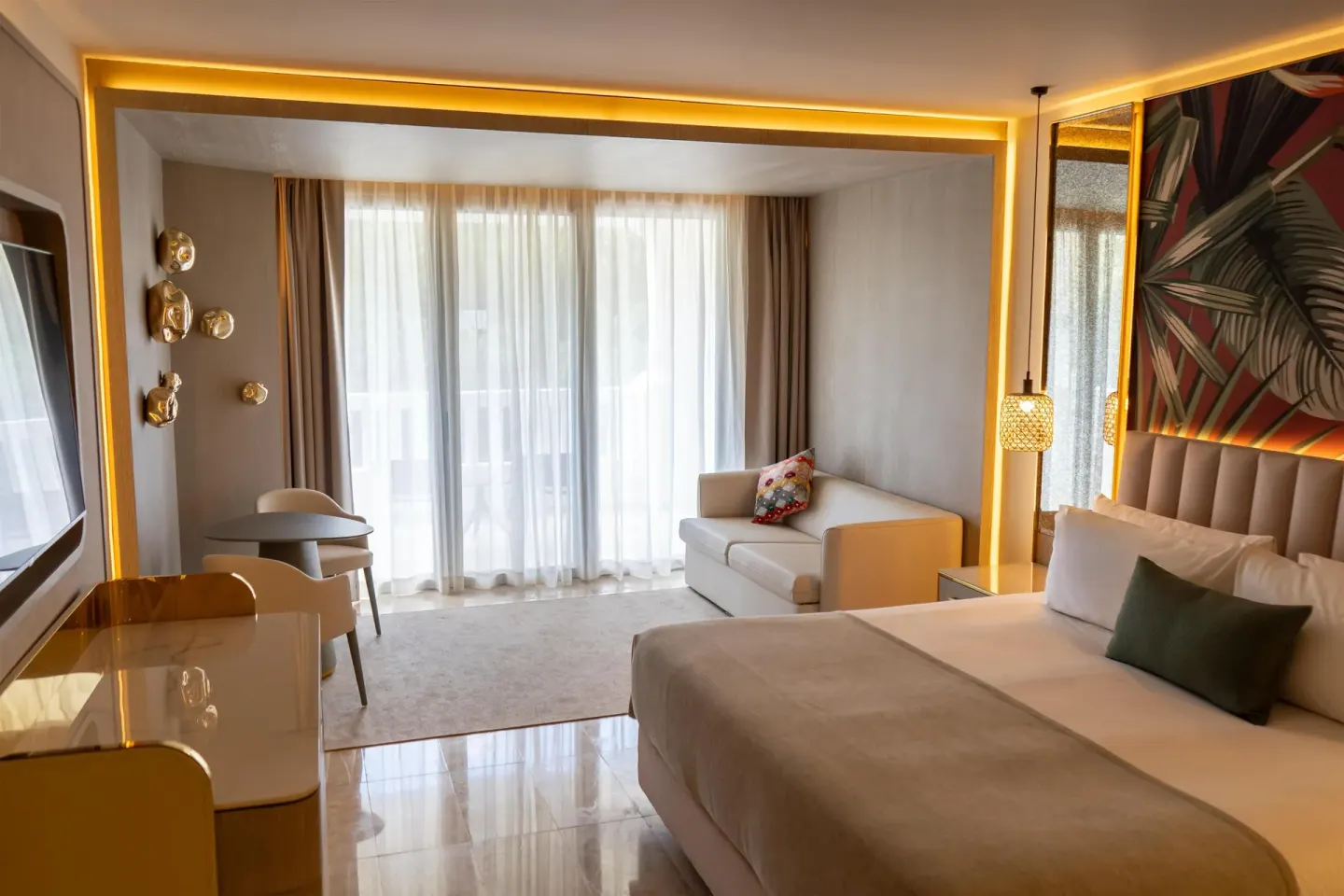 Guest room with king bed, sofa, desk and sheer balcony curtains at Grand Riviera Princess.